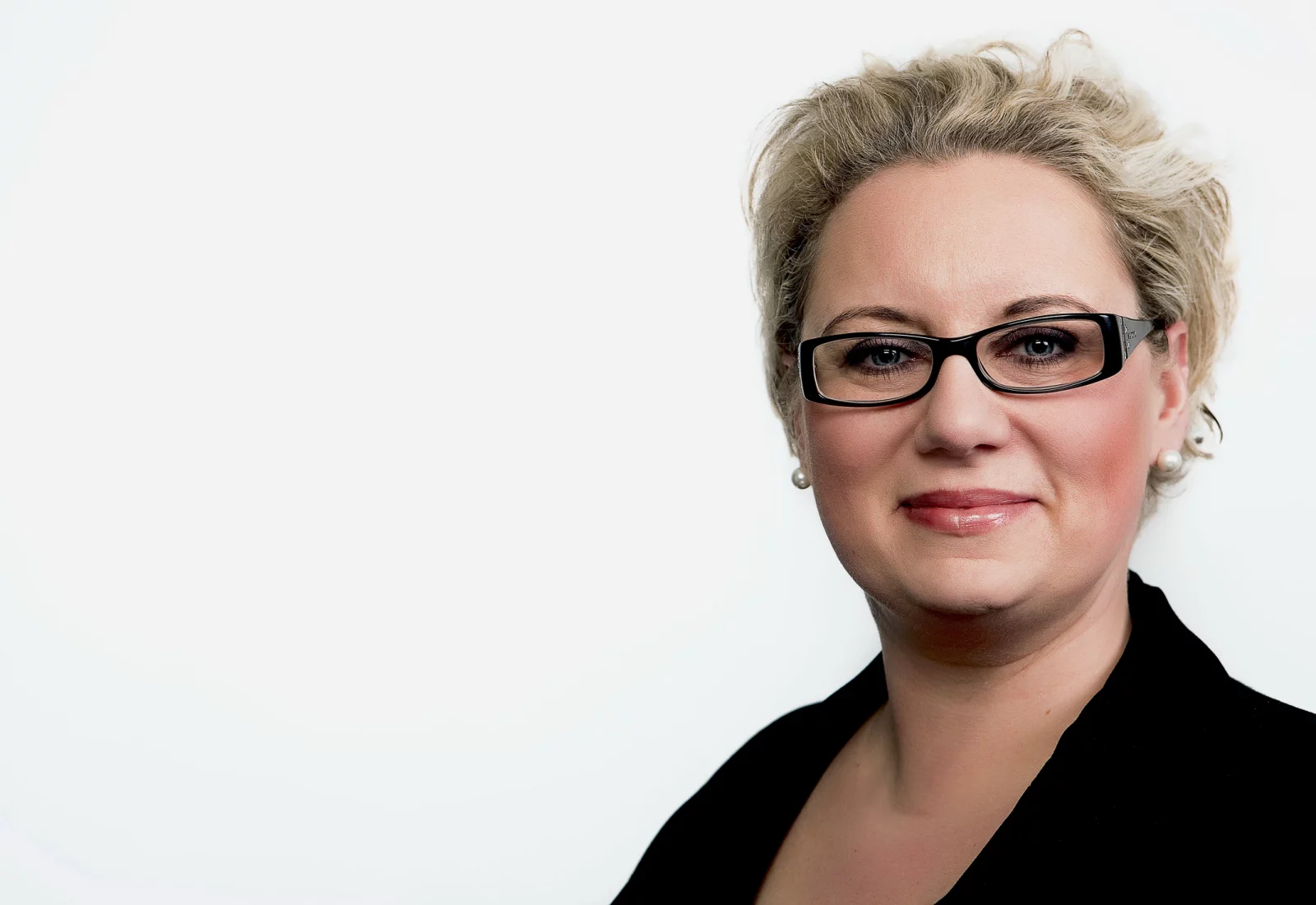 Modernes Bewerbungsfoto mit Brille vor hellem Hintergrund
