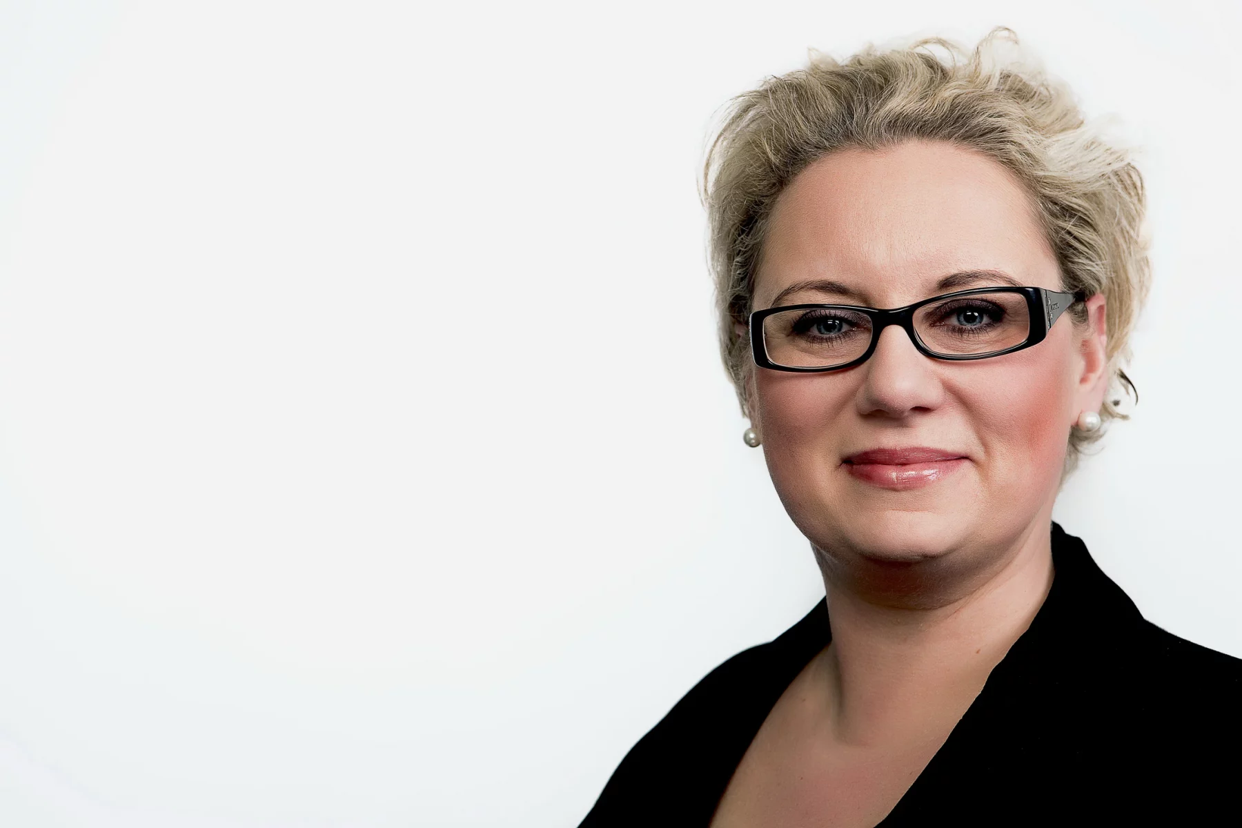 Modernes Bewerbungsfoto mit Brille vor hellem Hintergrund